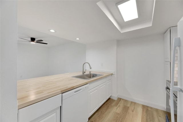 kitchen with ceiling fan, dishwasher, white cabinets, and sink