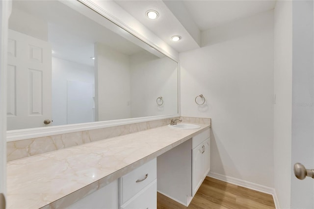 bathroom with wood finished floors, vanity, and baseboards