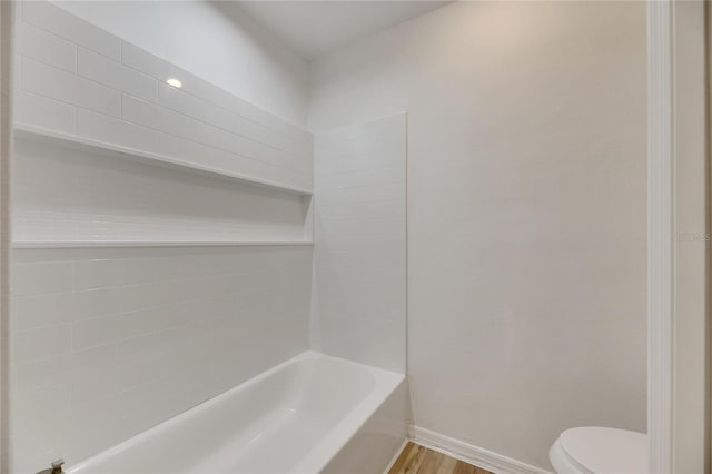 bathroom featuring hardwood / wood-style flooring, toilet, and washtub / shower combination