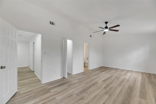 empty room featuring ceiling fan, light wood-type flooring, visible vents, and baseboards