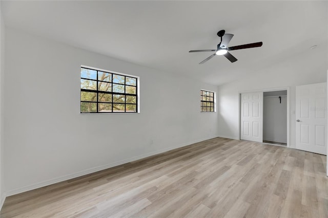 unfurnished bedroom featuring a closet, vaulted ceiling, ceiling fan, light wood-type flooring, and baseboards