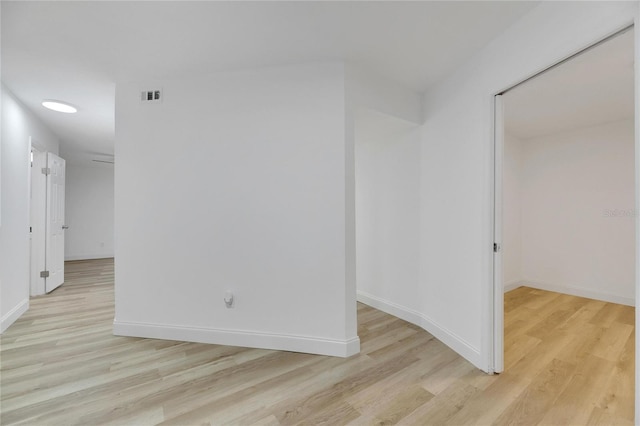 spare room with baseboards and light wood finished floors