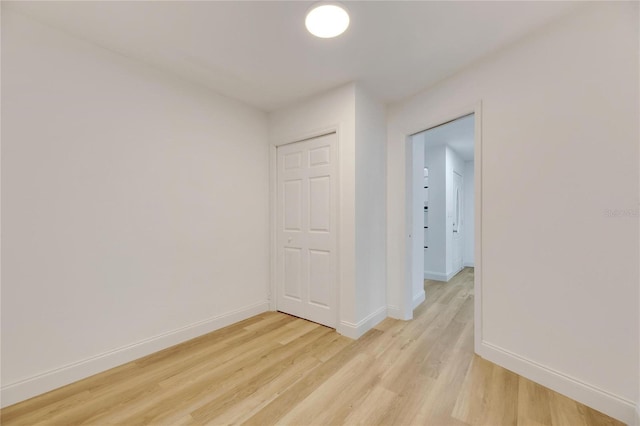 unfurnished room with light wood-type flooring and baseboards