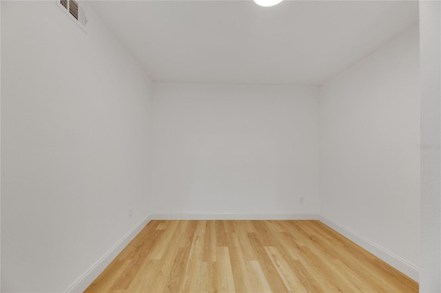 unfurnished room featuring light wood-type flooring, visible vents, and baseboards