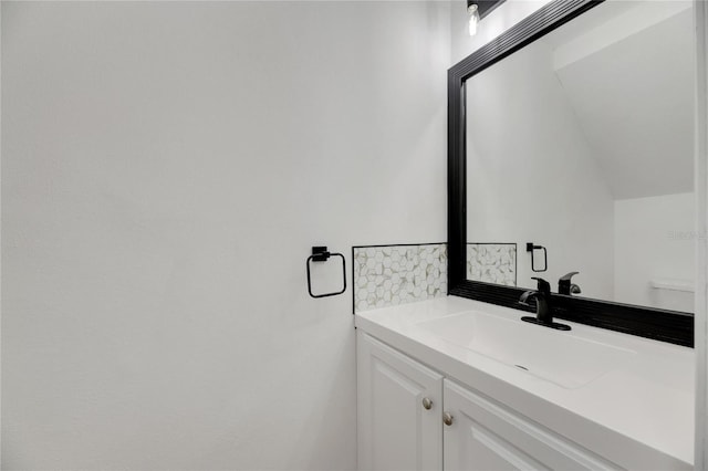 bathroom featuring vaulted ceiling and vanity