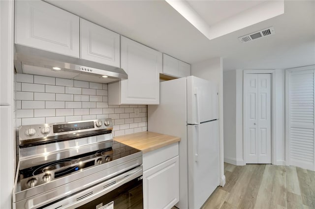 kitchen featuring under cabinet range hood, visible vents, white cabinets, stainless steel electric range, and freestanding refrigerator