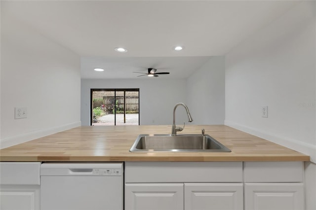 kitchen with white cabinets, dishwasher, wood counters, and a sink