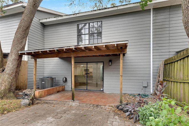 rear view of property with a patio area, fence, and cooling unit