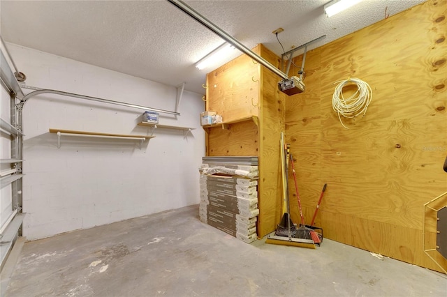 interior space with a garage, concrete block wall, and a textured ceiling