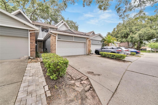 view of front of house featuring a garage, driveway, and brick siding