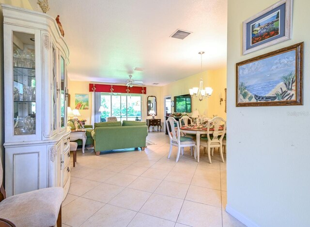 living room featuring ceiling fan with notable chandelier and light tile patterned floors