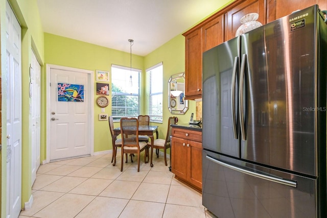 kitchen featuring stainless steel fridge, decorative light fixtures, and light tile patterned floors