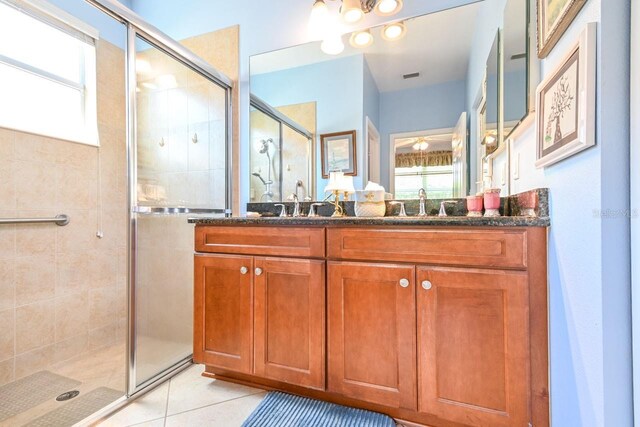 bathroom featuring tile patterned flooring, dual vanity, a notable chandelier, and an enclosed shower