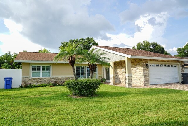 ranch-style home with a garage and a front lawn