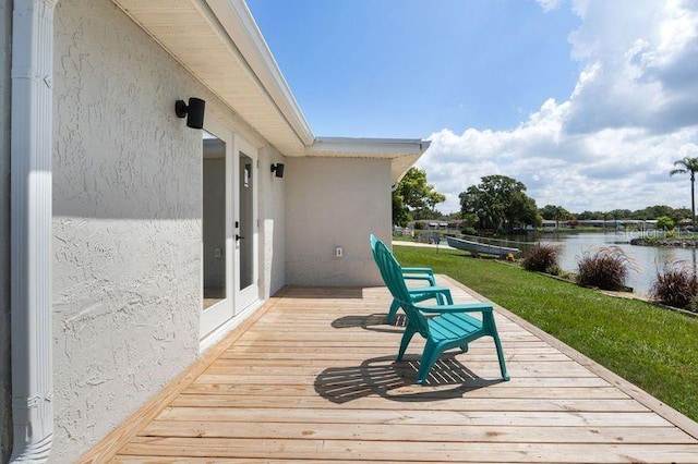 deck with a water view and a yard