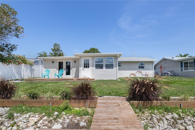 rear view of house with a yard and french doors