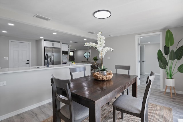 dining room with sink and light wood-type flooring