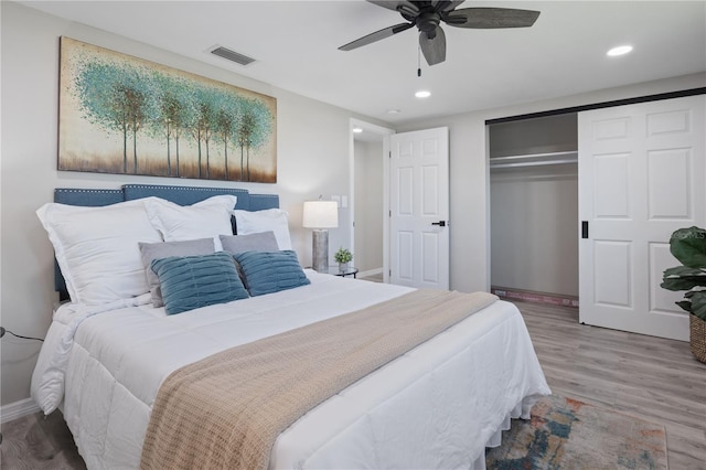 bedroom with wood-type flooring, a closet, and ceiling fan