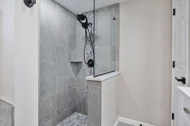 bathroom featuring vanity and tiled shower