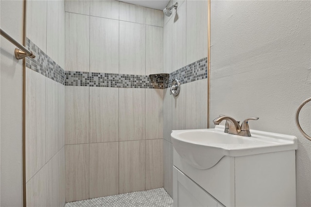 bathroom with vanity and a tile shower