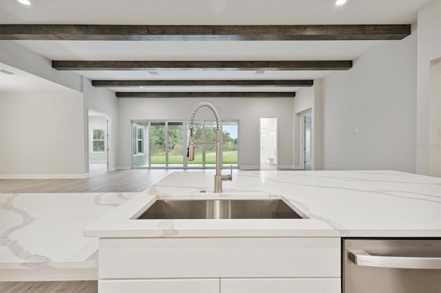 kitchen featuring sink, light stone counters, stainless steel dishwasher, light hardwood / wood-style flooring, and beam ceiling