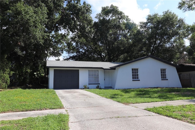 ranch-style home with a garage and a front lawn