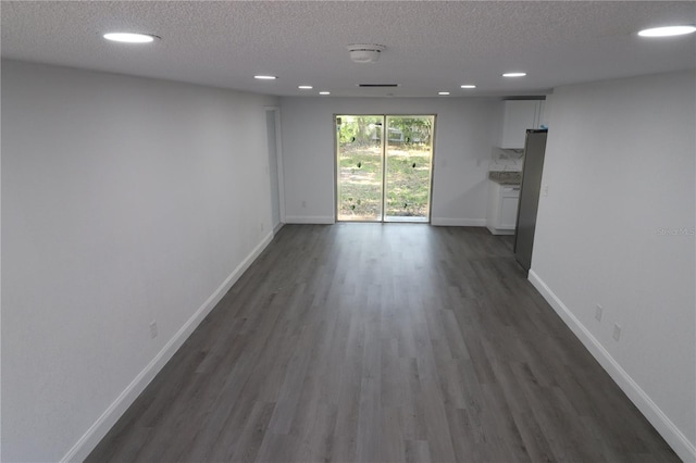 spare room with dark hardwood / wood-style floors and a textured ceiling