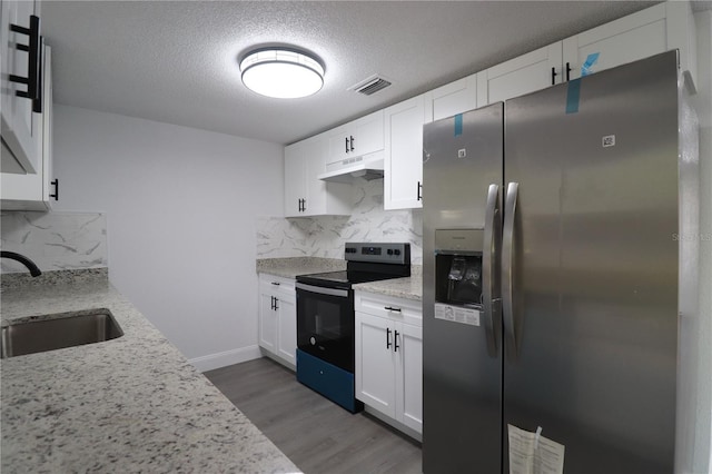 kitchen featuring decorative backsplash, white cabinets, sink, black electric range, and stainless steel fridge with ice dispenser