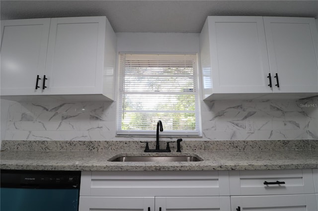 kitchen with decorative backsplash, sink, white cabinets, and black dishwasher