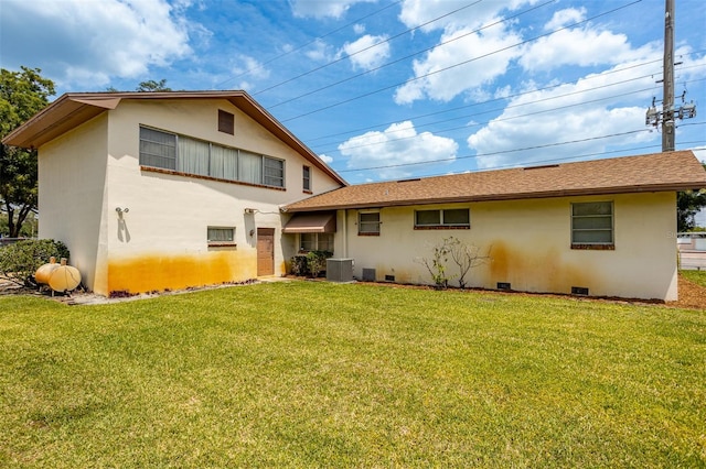 rear view of house featuring cooling unit, crawl space, a yard, and stucco siding