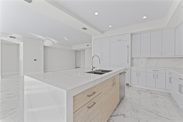 kitchen with white cabinetry, sink, light brown cabinets, stainless steel dishwasher, and a large island with sink