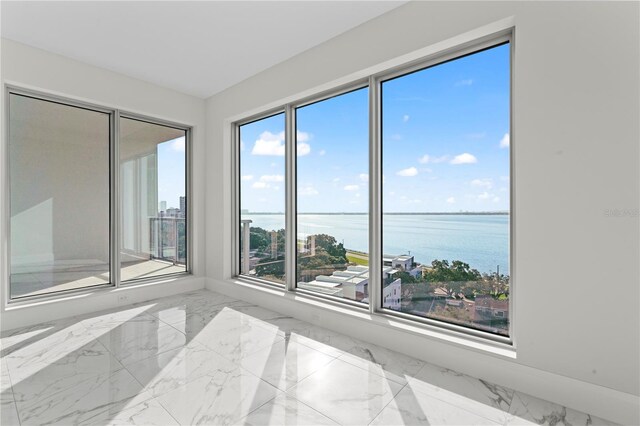 spare room featuring a water view and a wealth of natural light