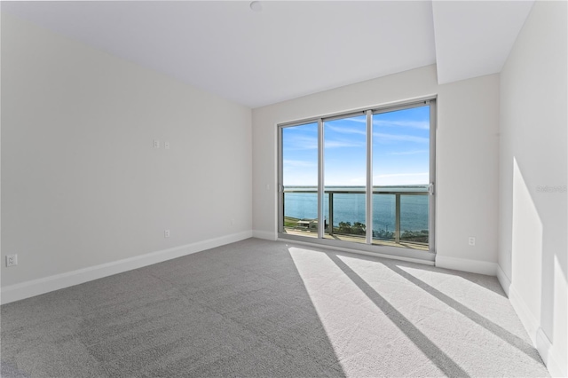 carpeted spare room with a water view