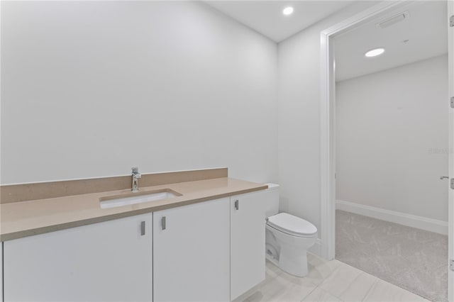 bathroom with tile patterned flooring, vanity, and toilet