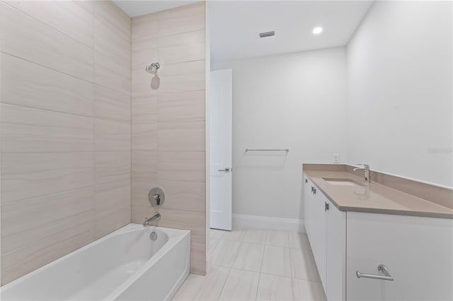 bathroom with tile patterned flooring, vanity, and tiled shower / bath combo