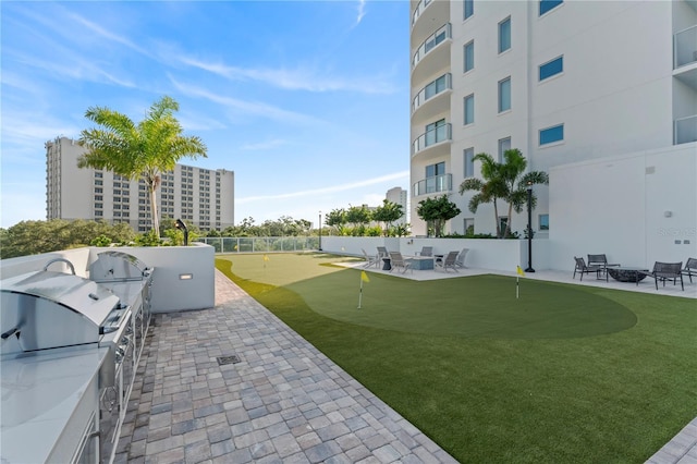 surrounding community with exterior kitchen and a patio