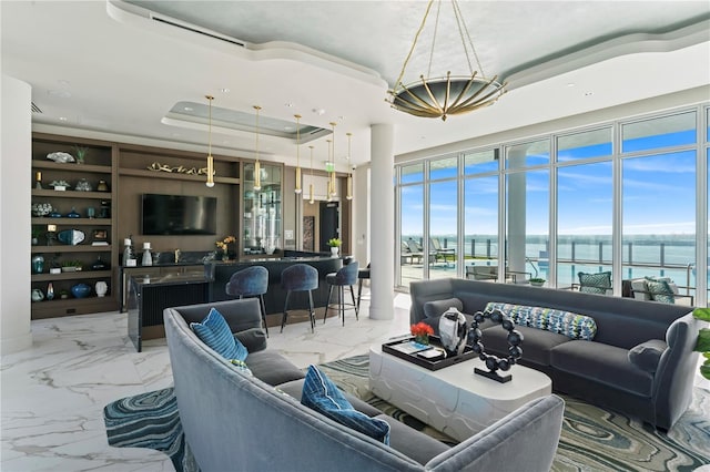 living room featuring indoor bar and a tray ceiling