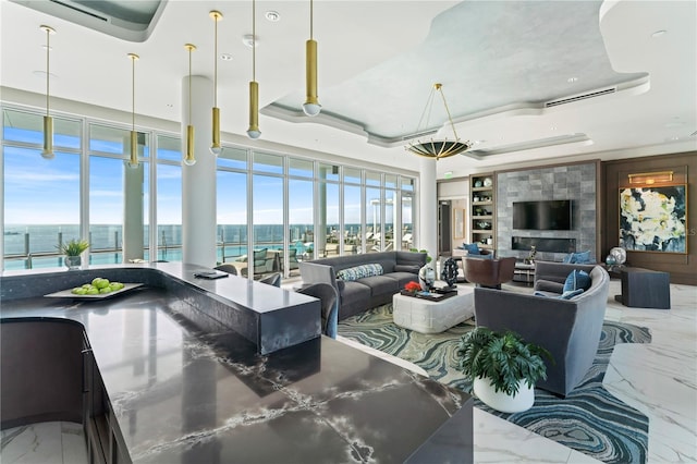 living room featuring a tray ceiling and a water view