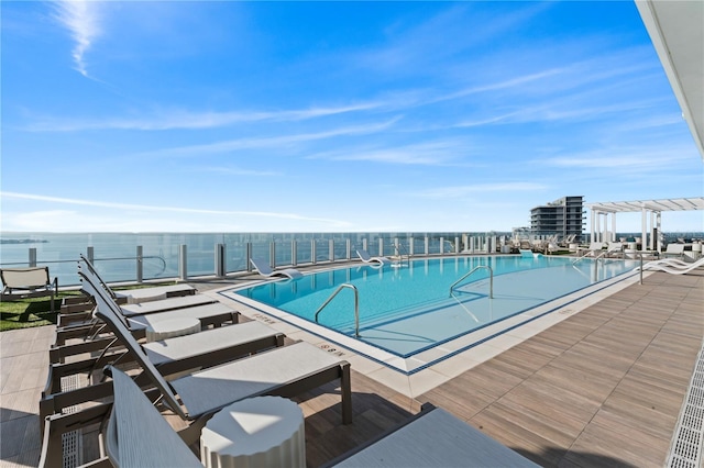 view of pool featuring a water view and a patio