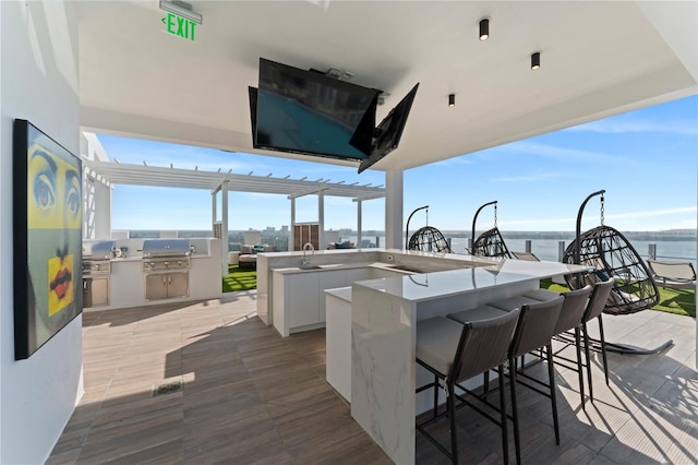 view of patio / terrace featuring an outdoor kitchen, a bar, and grilling area