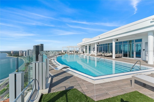 view of swimming pool featuring a patio and a water view