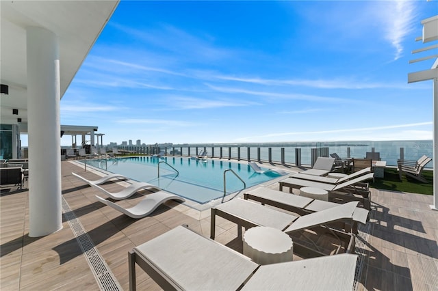 view of swimming pool featuring a patio area and a water view