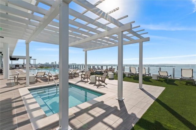 view of swimming pool featuring a water view, a pergola, a yard, and a patio