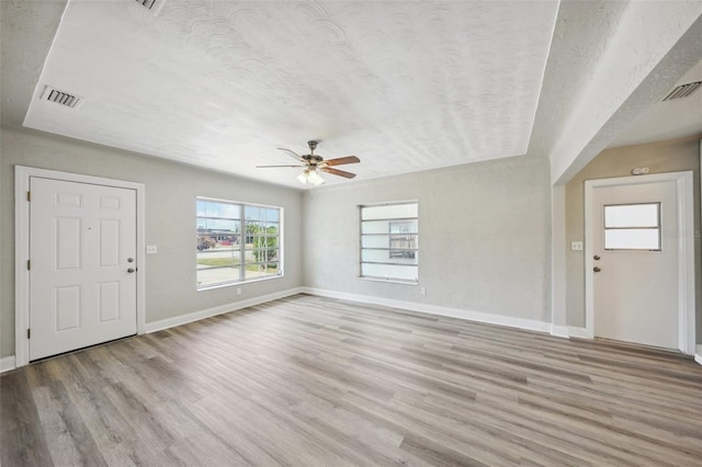 foyer entrance featuring a textured ceiling, light hardwood / wood-style flooring, and ceiling fan