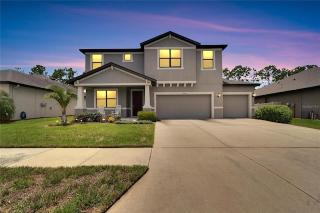 view of front of house with a lawn, a garage, and covered porch