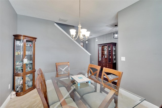 carpeted dining space with a chandelier