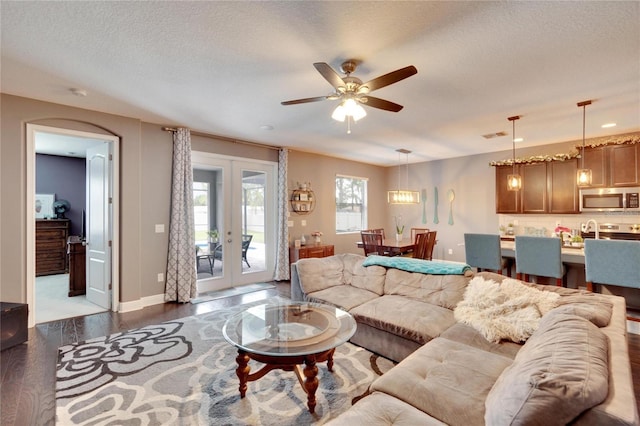 living room with french doors, sink, ceiling fan, a textured ceiling, and dark hardwood / wood-style flooring