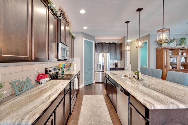 kitchen with wood counters, appliances with stainless steel finishes, backsplash, and decorative light fixtures