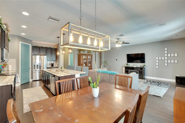 dining area featuring hardwood / wood-style flooring, ceiling fan, and sink