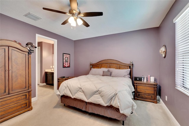 carpeted bedroom with ceiling fan and ensuite bath